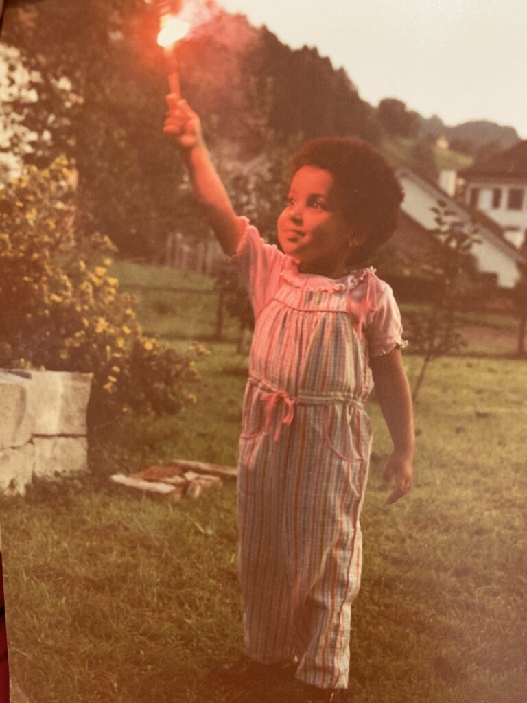 About the photo : I think I was about three or four when this picture was taken in my auntie’s backyard in Switzerland. The sense of wonder that comes with being a kid is so visceral and all encompassing and you can see it in the expression on my face. For me, that’s what dreams are made of — that child-like spirit, that spark.